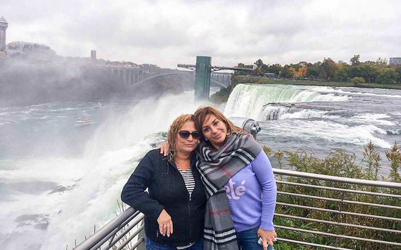 Visitors at Niagara Falls with view of the waterfall and Maid of the Mist boat in the background.