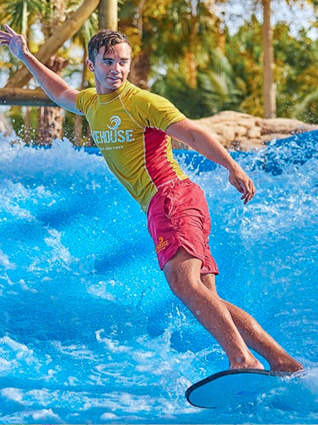 Surfer riding wave at Aquaventure Waterpark, Dubai.