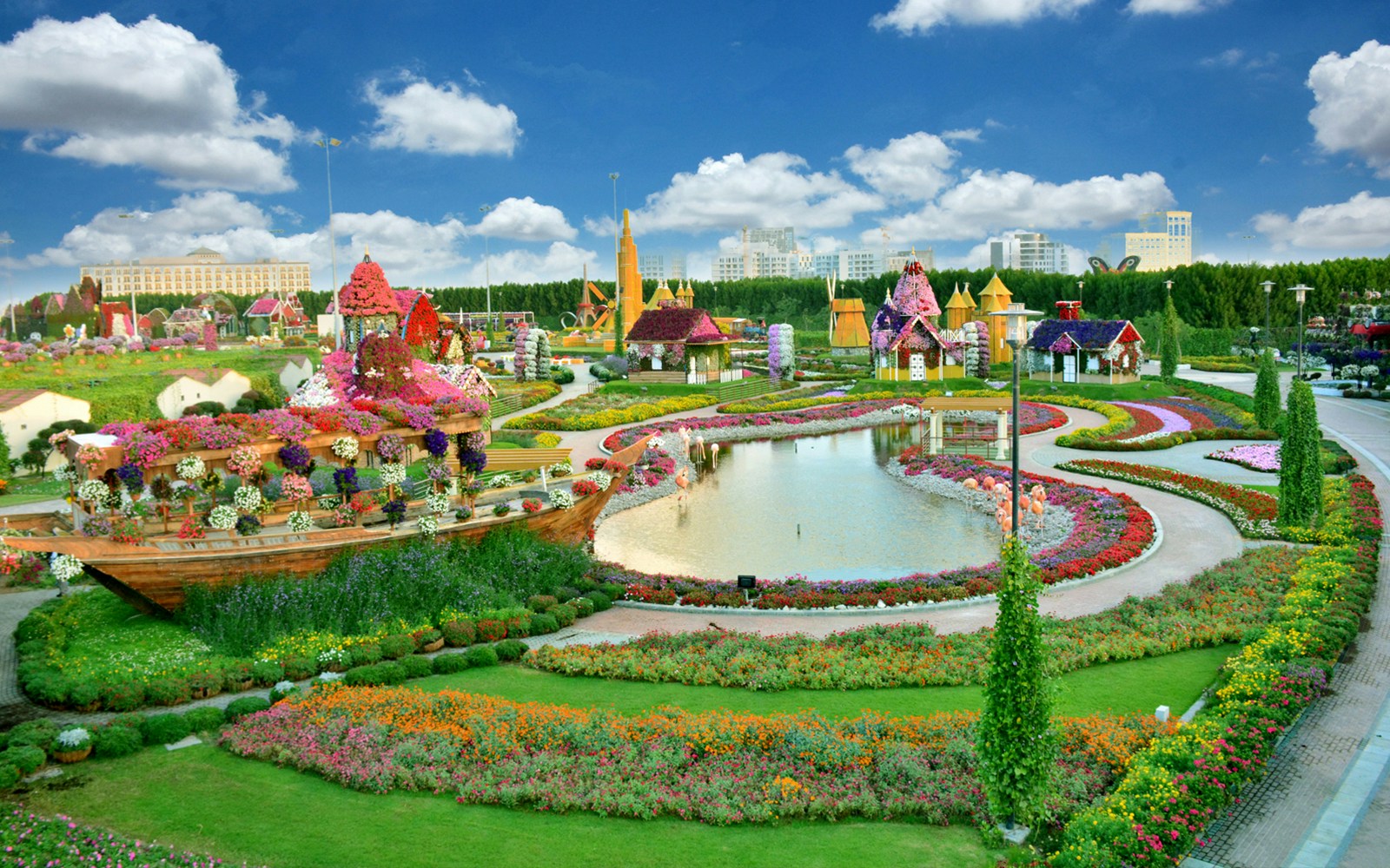 Dubai Miracle Garden with floral displays and a pond, featuring colorful flower arrangements and structures.