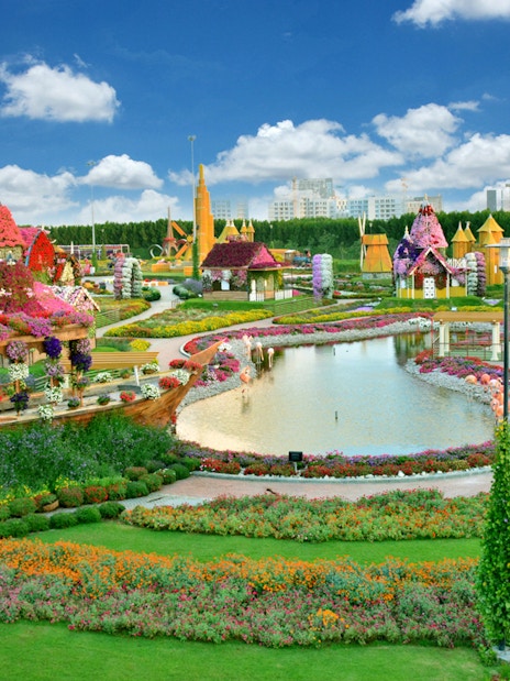 Dubai Miracle Garden with floral displays and a pond, featuring colorful flower arrangements and structures.
