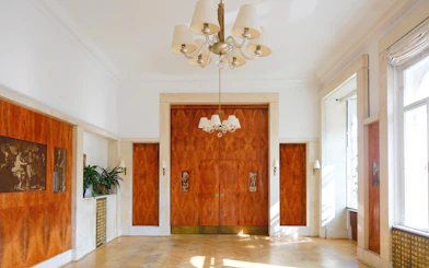 Adolf Loos-designed interior with wood paneling and chandelier in Wohnung Löwenbach.