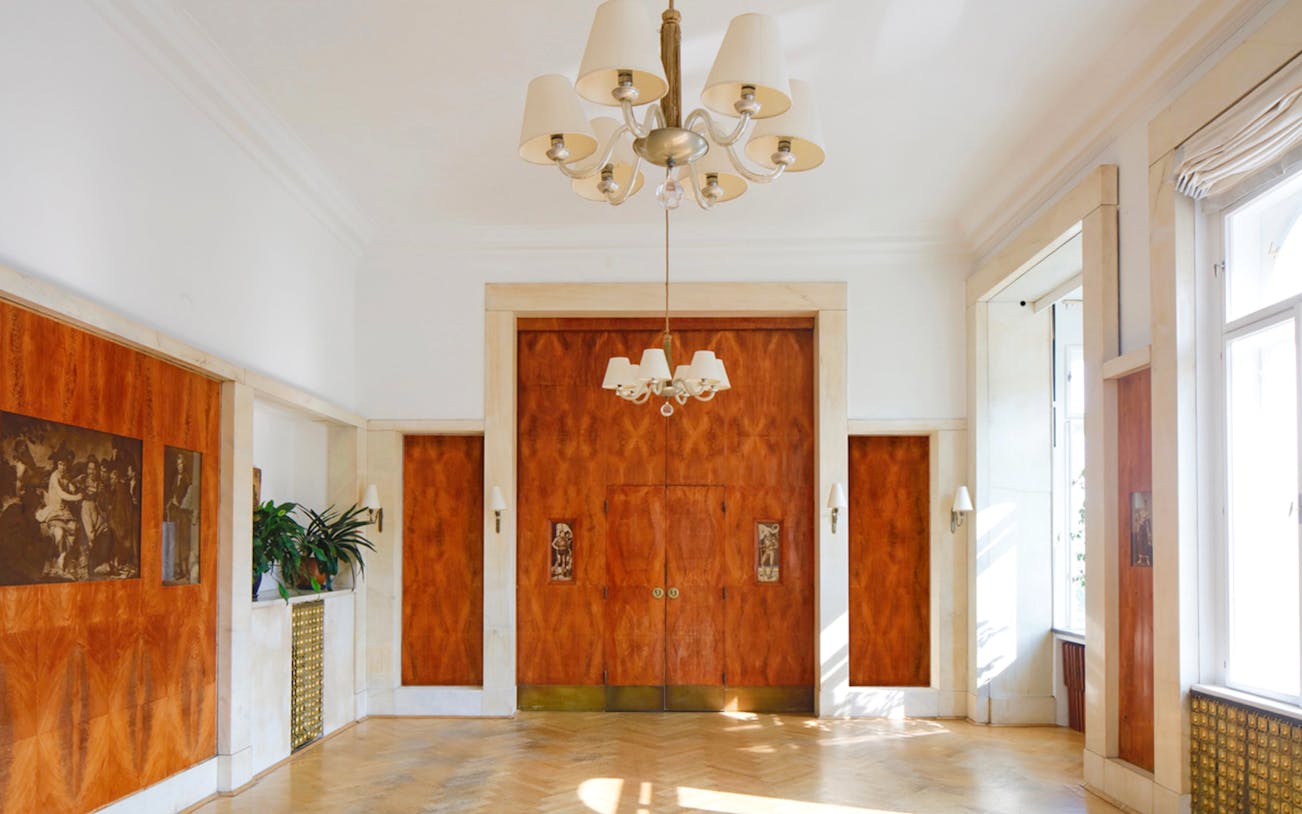 Adolf Loos-designed interior with wood paneling and chandelier in Wohnung Löwenbach.