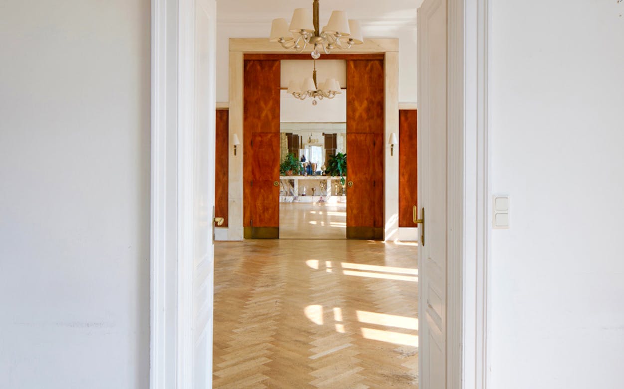 Interior view of Adolf Loos-designed Löwenbach apartment with wooden doors and parquet flooring.