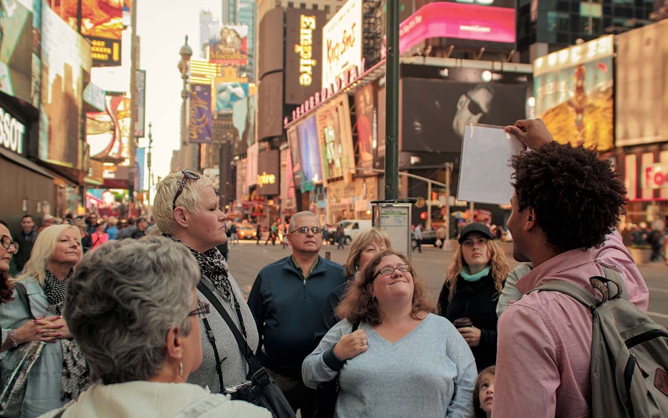 Group tour in Times Square, New York City, led by a guide for the Disney on Broadway experience.