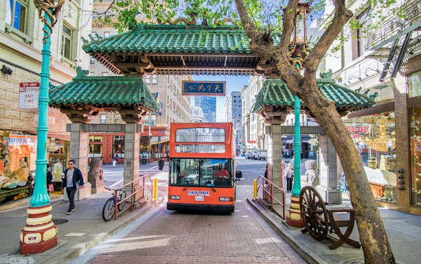 Double-decker bus passing through Chinatown Gate, San Francisco, on a city tour.