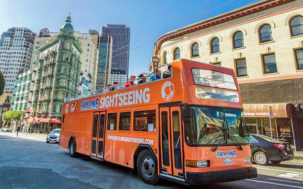 Open-top sightseeing bus on a city street during a Hop-On Hop-Off City Day Tour.