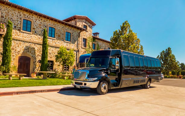 Tour bus parked outside a stone winery building in Sonoma Valley.