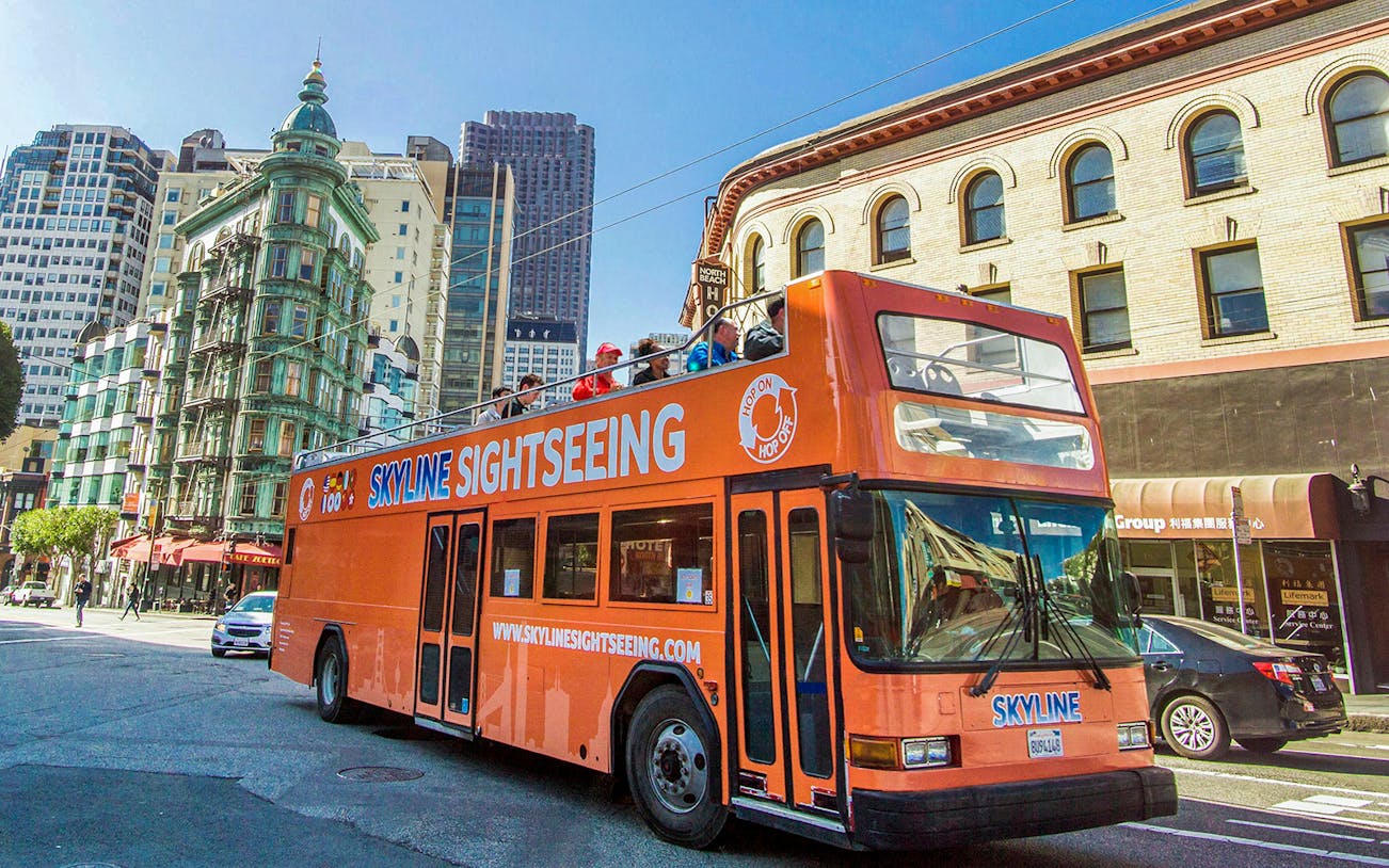 Open-top tour bus in San Francisco city street, heading to Sonoma Valley wine country.