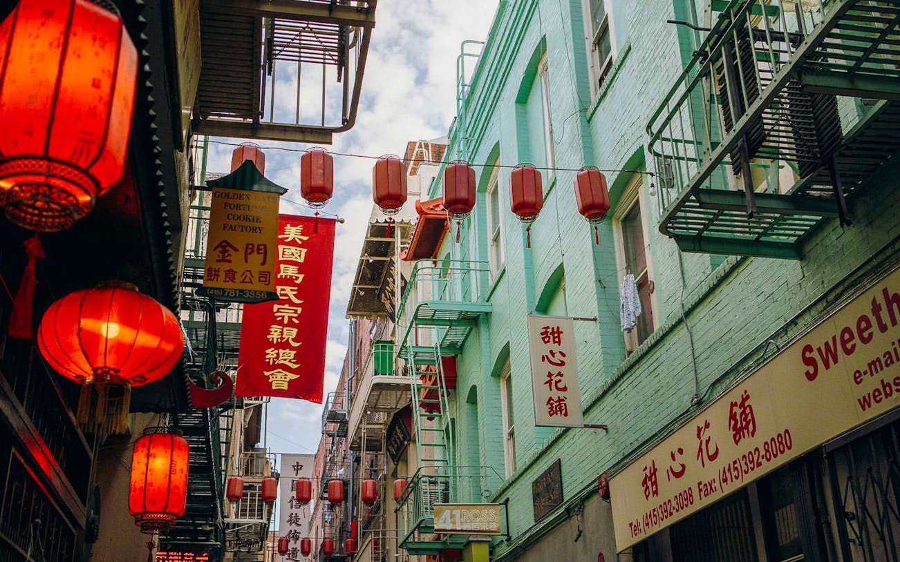 Red lanterns and signs in San Francisco's Chinatown alley, part of the Through The Dragon Gate tour.