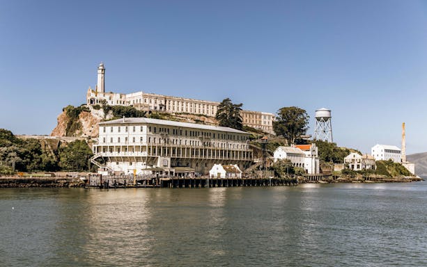 Alcatraz Island view from the water, featuring historic prison buildings and lighthouse.