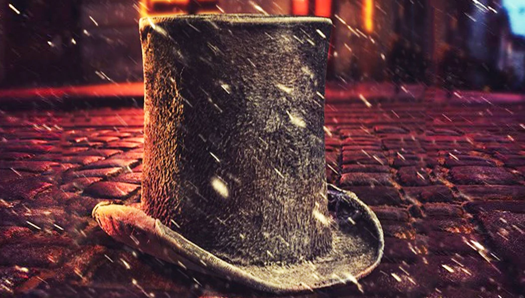 Top hat on cobblestone street with snow, evoking Cratchit scene.