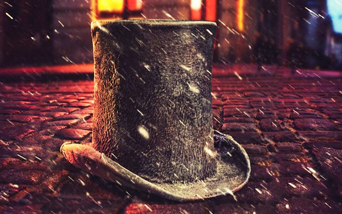 Top hat on cobblestone street with snow, evoking Cratchit scene.