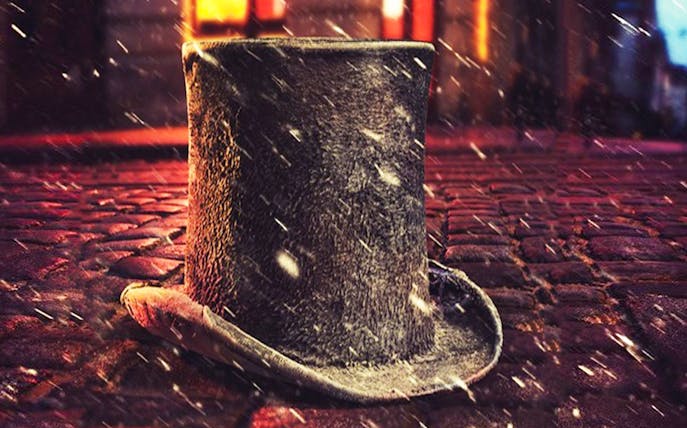 Top hat on cobblestone street with snow, evoking Cratchit scene.