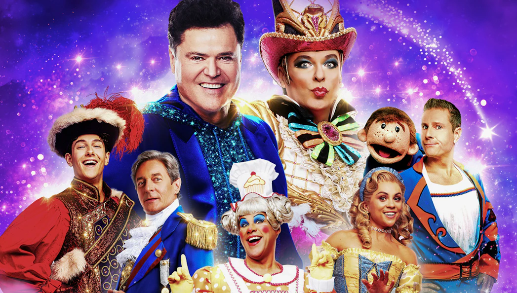 Colorful cast of performers in vibrant costumes for Pantoland show.