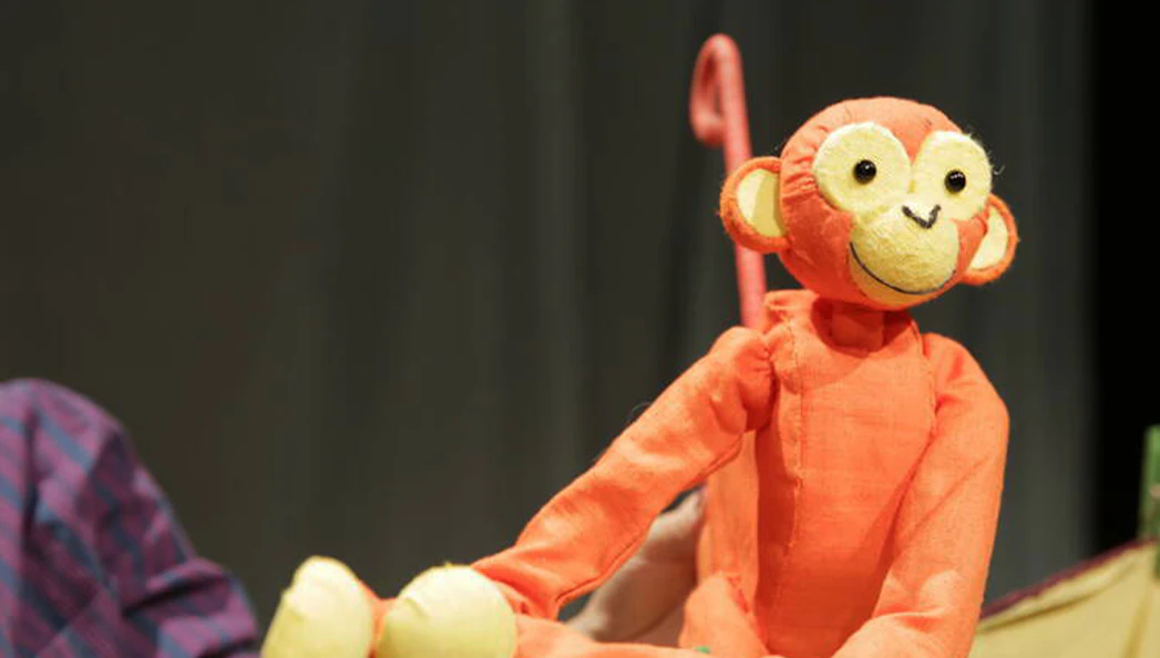 Orange monkey puppet from Five Little Christmas Monkeys show.