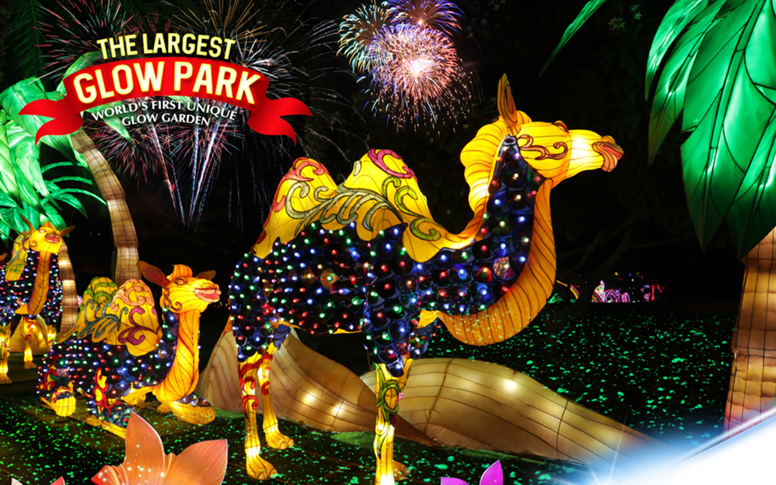 Illuminated camel sculptures at Dubai Garden Glow with fireworks in the background.