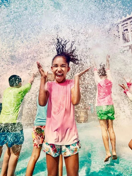 Children playing under water splash at Yas Waterworld, Abu Dhabi.