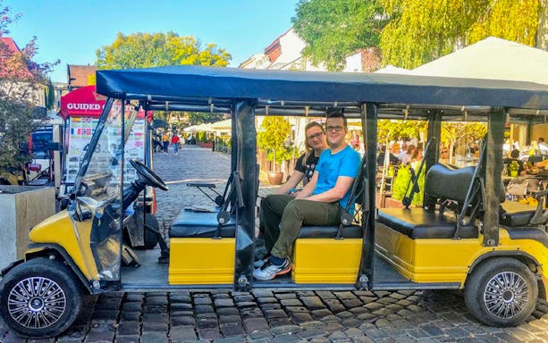 Golf cart tour in Krakow's Kazimierz Quarter with passengers seated.