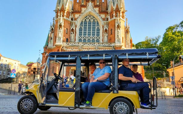 Golf cart tour in front of a historic church in Krakow's Kazimierz Quarter.