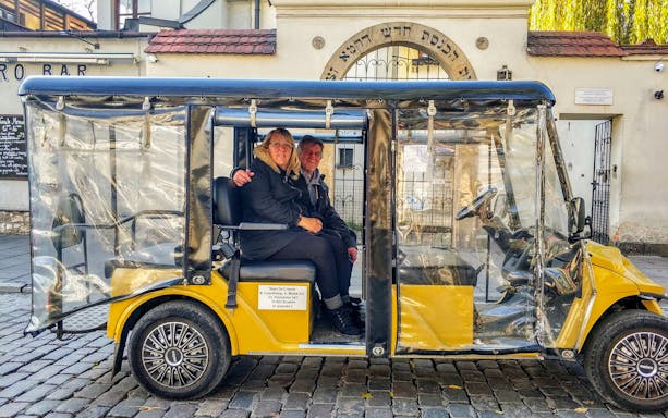 Golf cart tour in Krakow's Kazimierz Quarter near historic synagogue.