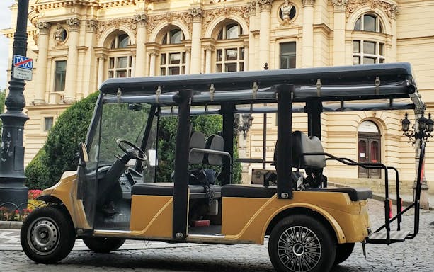 Golf cart in front of historic building in Krakow's Old Town.