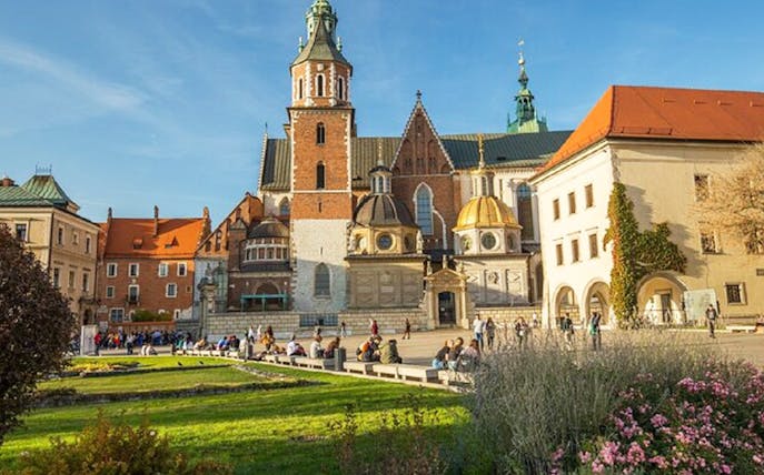 Wawel Castle courtyard in Krakow with tourists exploring the historic site.
