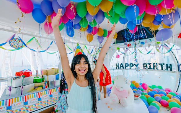 Celebration inside Ain Dubai cabin with balloons and gifts, part of IMG Worlds of Adventure combo.