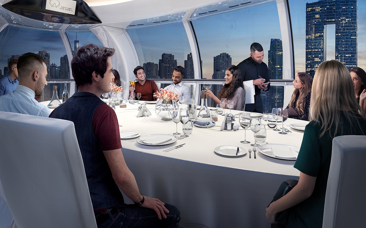 Dining experience inside Ain Dubai capsule with city skyline view.