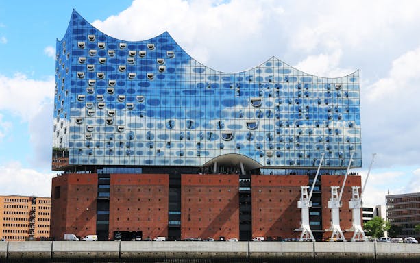 Elbphilharmonie in Hamburg with modern glass facade reflecting sky, part of UNESCO tour.