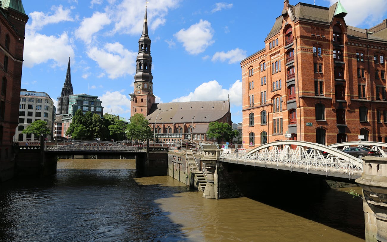 Speicherstadt canal view with historic warehouses, HafenCity, and Elbphilharmonie, Hamburg UNESCO tour.