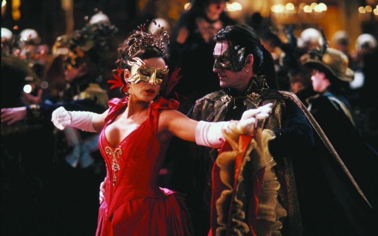 The Palazzo Vendramin-Calergi building on the banks of the Grand Canal in Venice, with a grand masquerade ball setting.