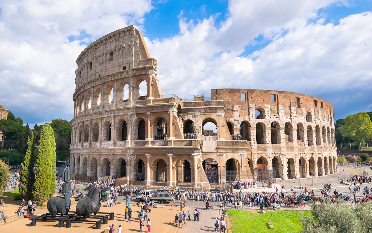 Colosseum in Rome with tourists entering through reserved arena floor entrance.