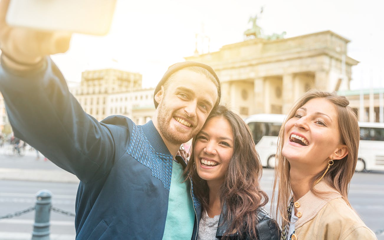Tourists taking a selfie in front of the Brandenburg Gate, Berlin.