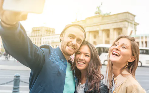 Tourists taking a selfie in front of the Brandenburg Gate, Berlin.
