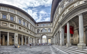 Uffizi Gallery courtyard in Florence, Italy, with visitors exploring the historic architecture.