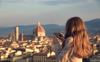 Woman photographing Florence skyline with Florence Cathedral in view.