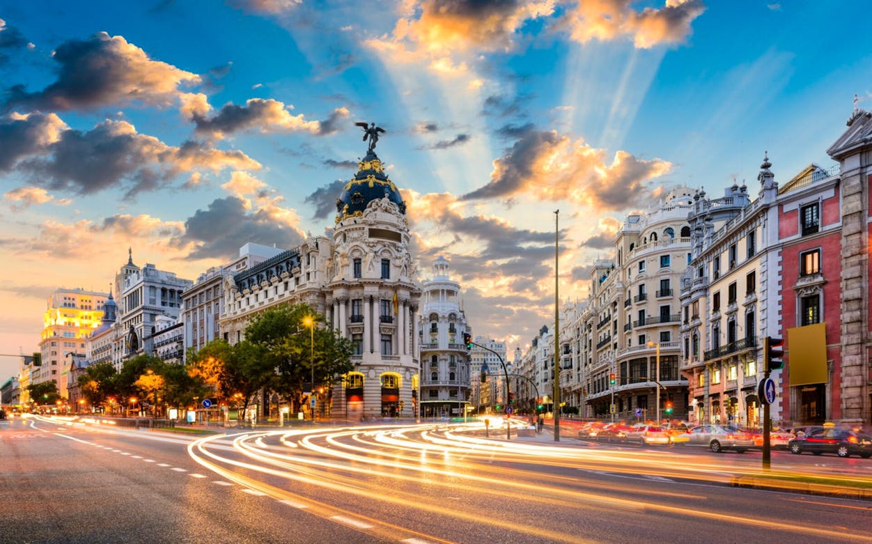 Gran Vía street in Madrid at sunset with Metropolis Building.