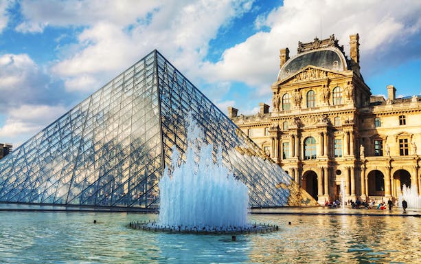 Louvre Pyramid and fountain in Paris during a self-guided audio tour.