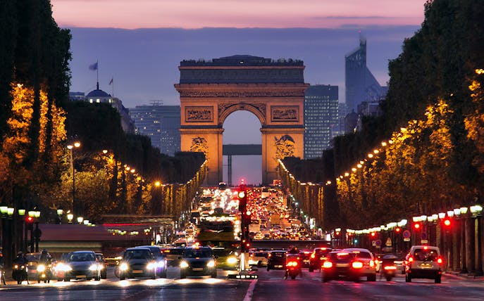 Arc de Triomphe at dusk with traffic on Champs-Élysées, Paris Self Guided Audio Tour.