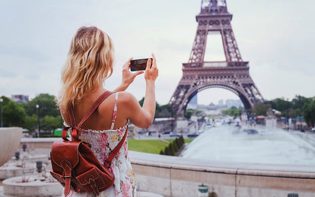 Person taking photo of Eiffel Tower during Paris self-guided audio tour.