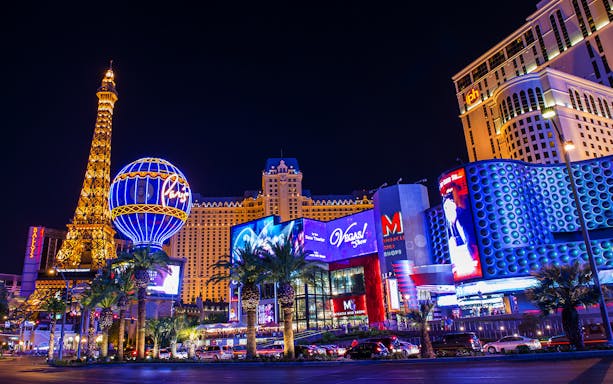 Las Vegas Strip at night with Paris Hotel and Eiffel Tower replica.
