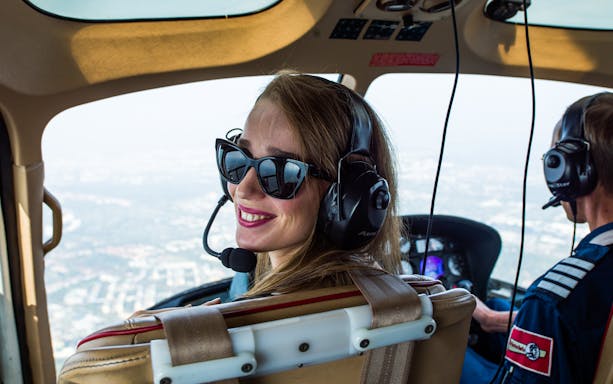 Helicopter tour over Berlin with pilot and passenger wearing headsets.