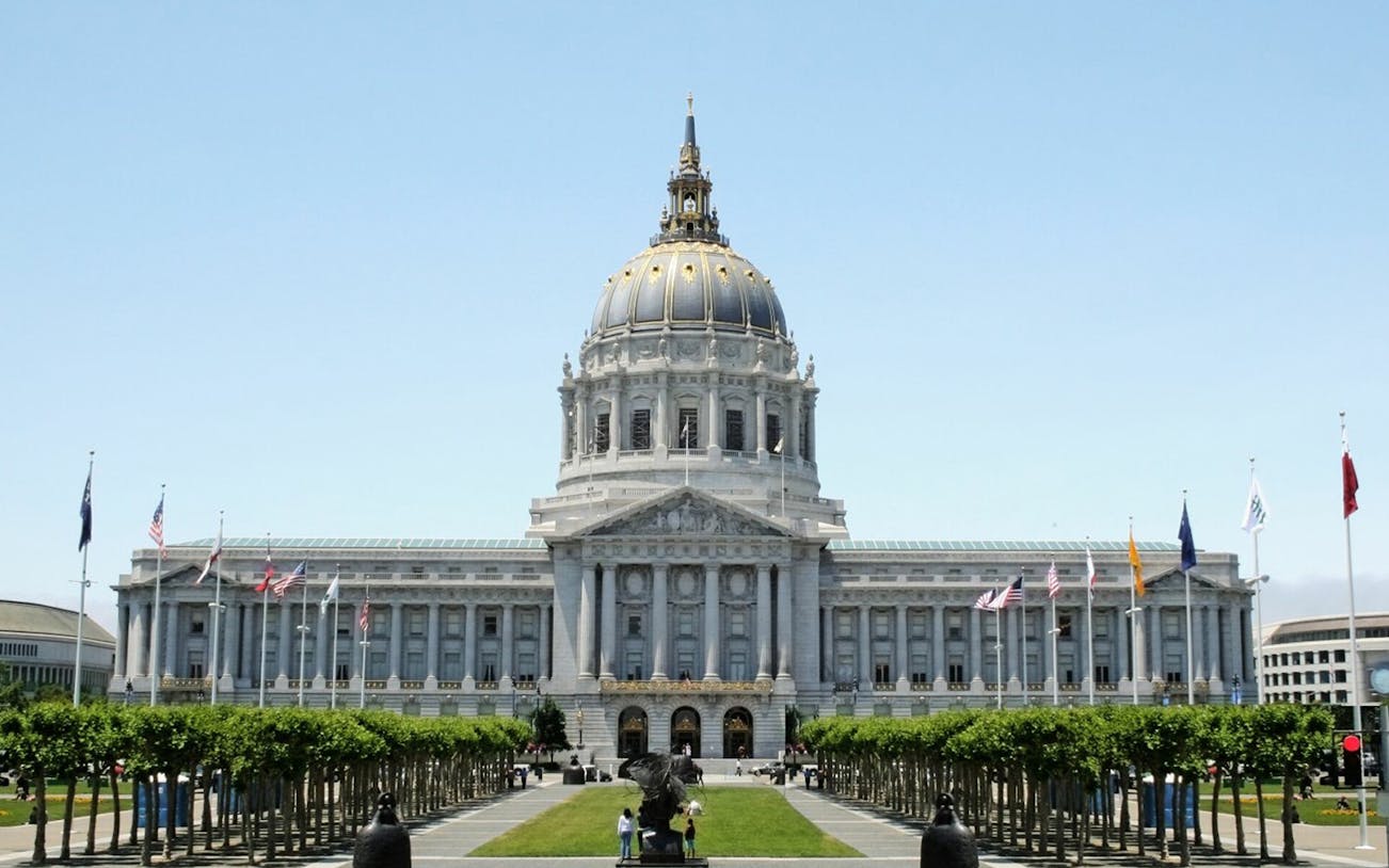 San Francisco City Hall with flags and trees, part of self-guided audio tour.