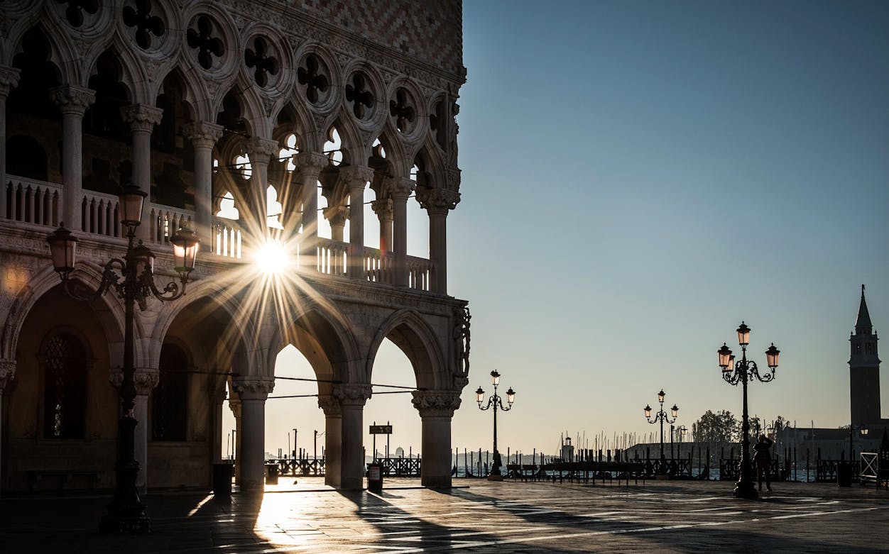 Doge Palace arches with sunrise in Venice, Italy, viewed during self-guided audio tour.