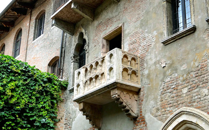 Juliet's balcony in Verona, Italy, covered in ivy, part of the self-guided audio tour.