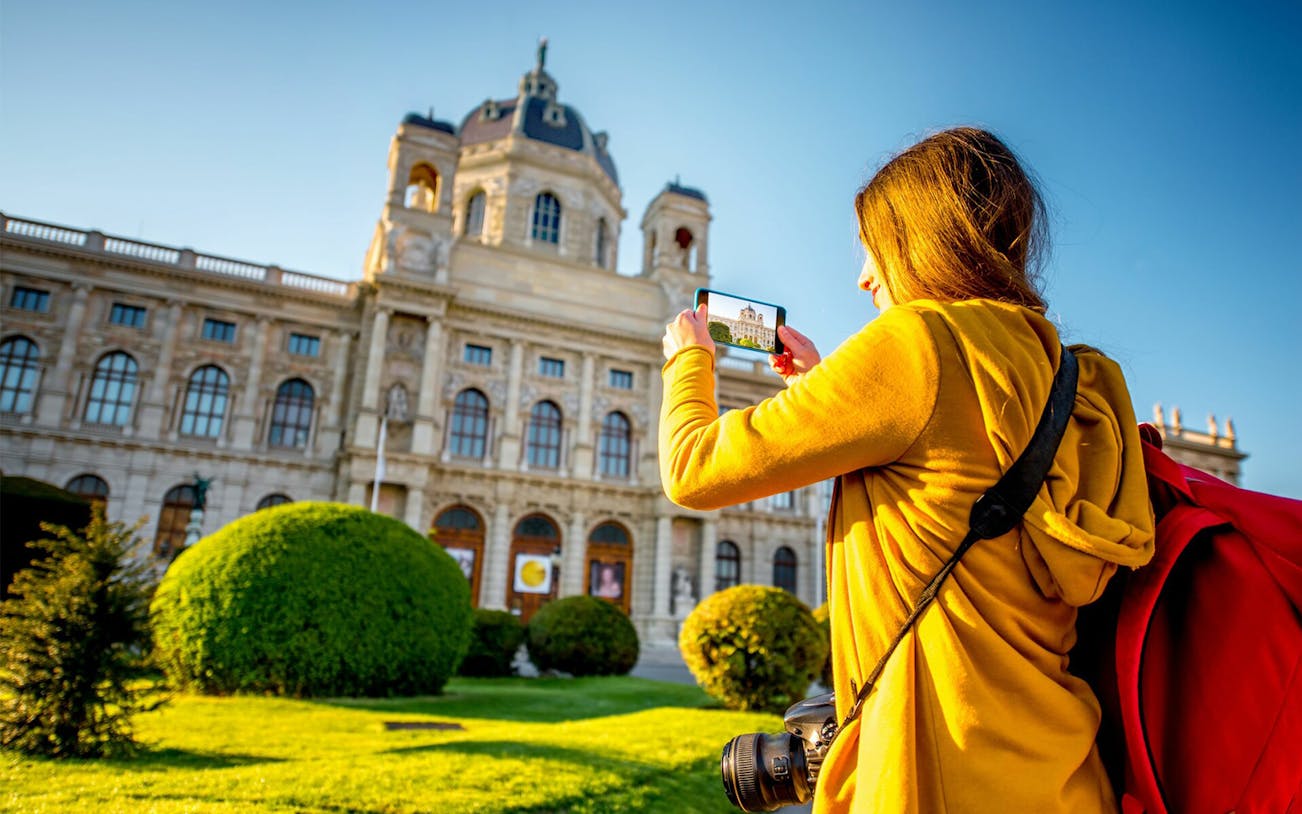 Visitor photographing the Kunsthistorisches Museum in Vienna during a self-guided audio tour.