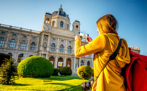Visitor photographing the Kunsthistorisches Museum in Vienna during a self-guided audio tour.