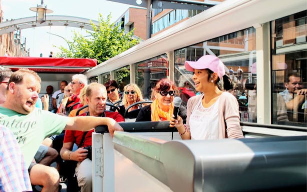 Tour guide speaking to passengers on a HopOn HopOff sightseeing bus tour.