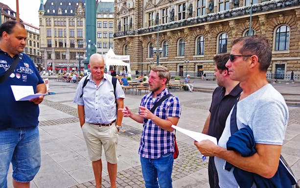 Tour group discussing in front of Hamburg's historic town hall.