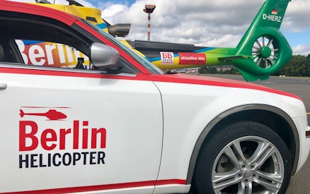 Berlin helicopter and car on tarmac, related to Candle Flight Dinner tour.